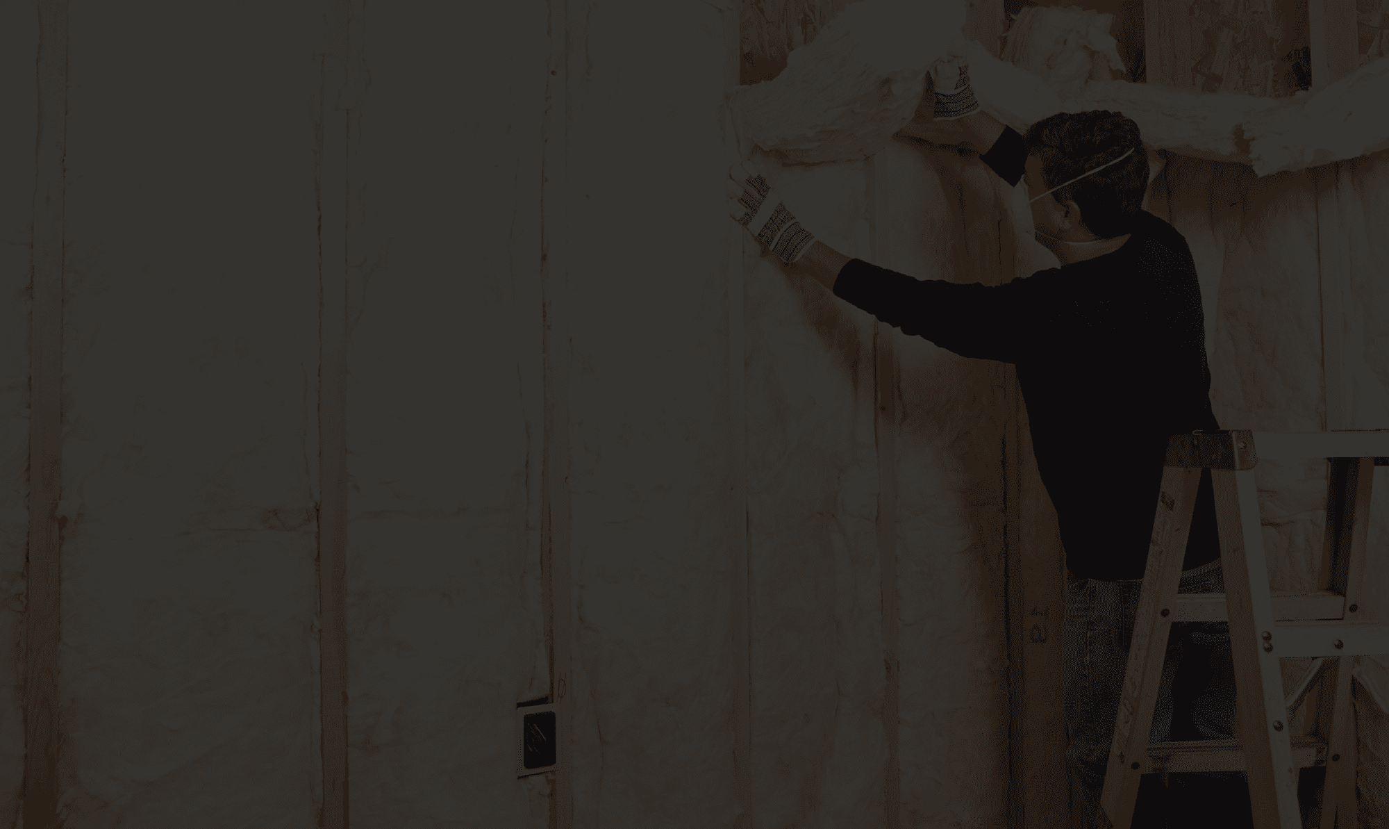 Installer fitting insulation between internal wall studs