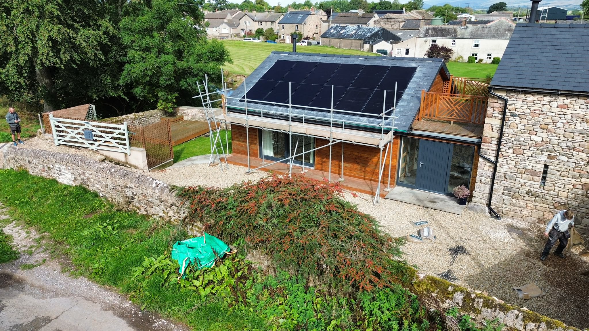 Property view showing the solar installation, timber cladding and stonework